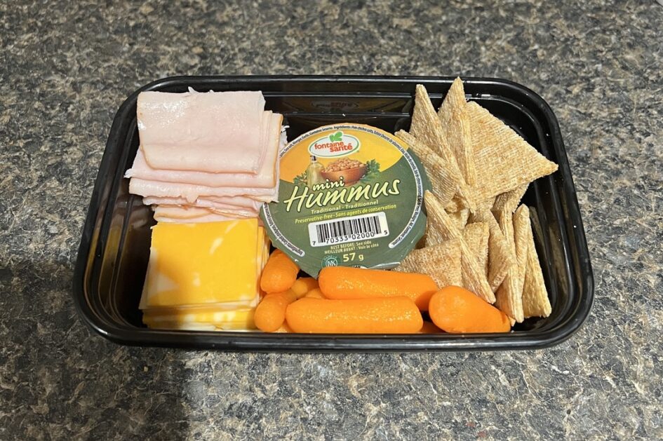 Sliced deli turkey, sliced cheese, mini hummas container, baby carrots, cracker in a container