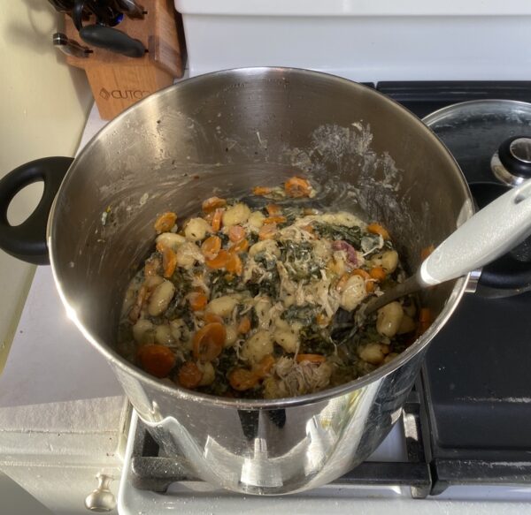 Gnocchi in a pot with shredded chicken, bacon, and vegetables