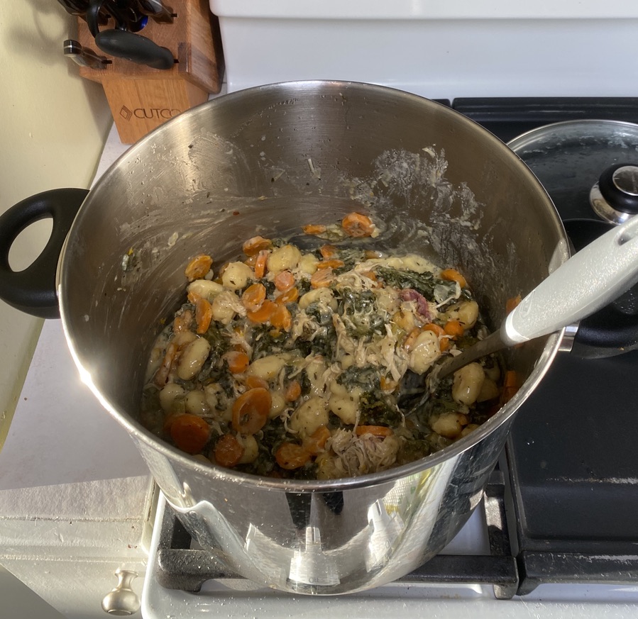 Gnocchi in a pot with shredded chicken, bacon, and vegetables