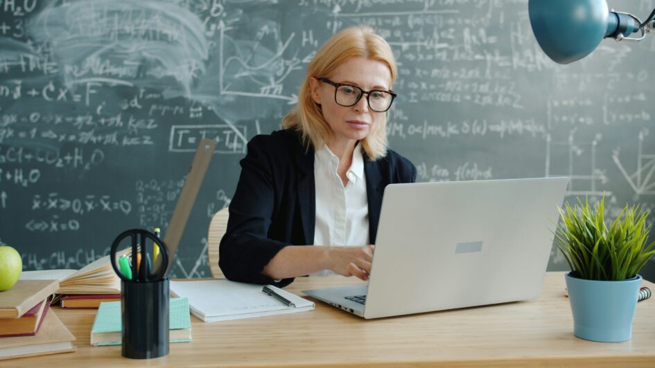 Teacher working on her computer in a classroom